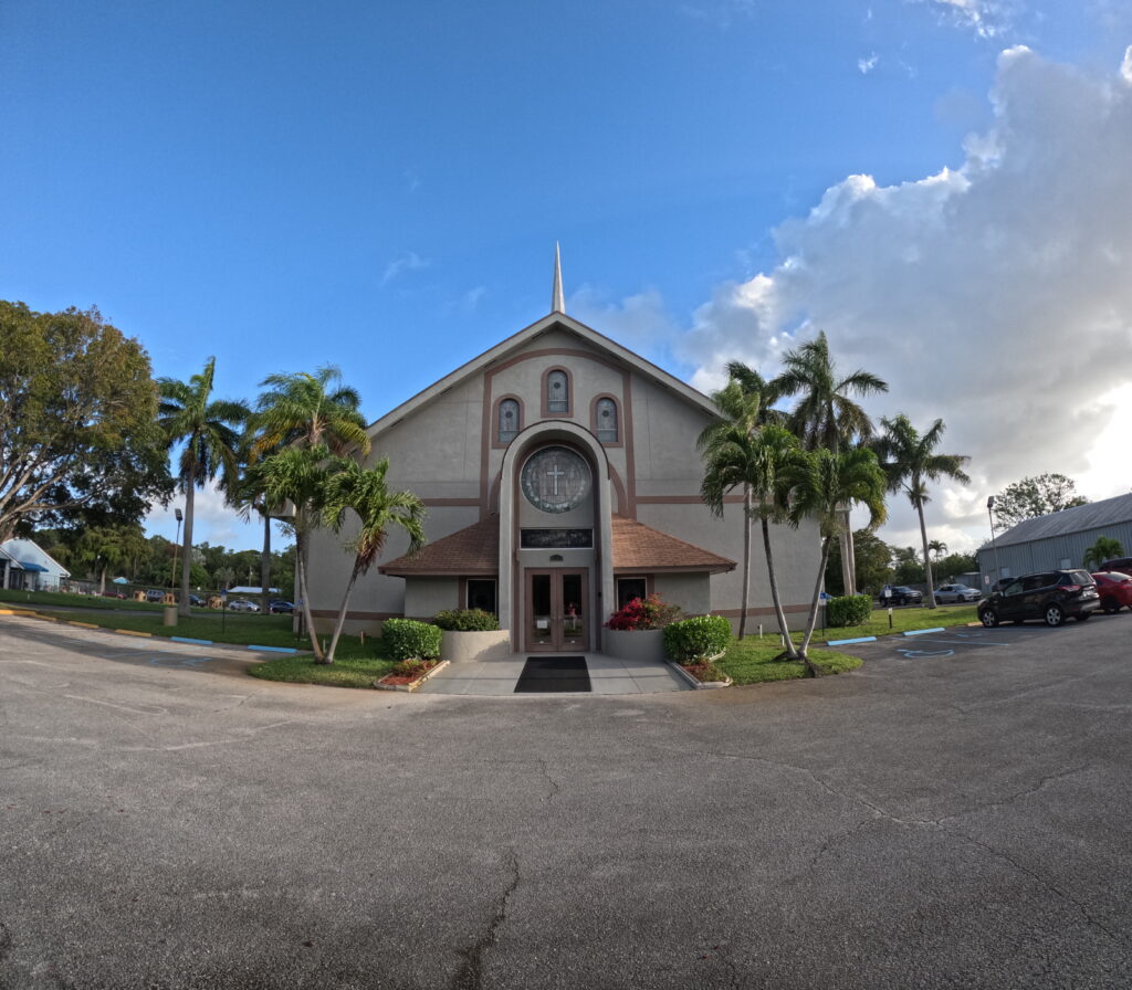 West Side Baptist Church entrance with Sunday service times listed in English and Spanish